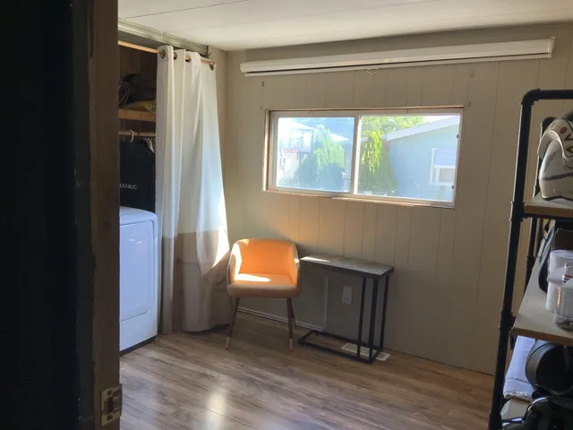 a view of a hallway with wooden floor and a window