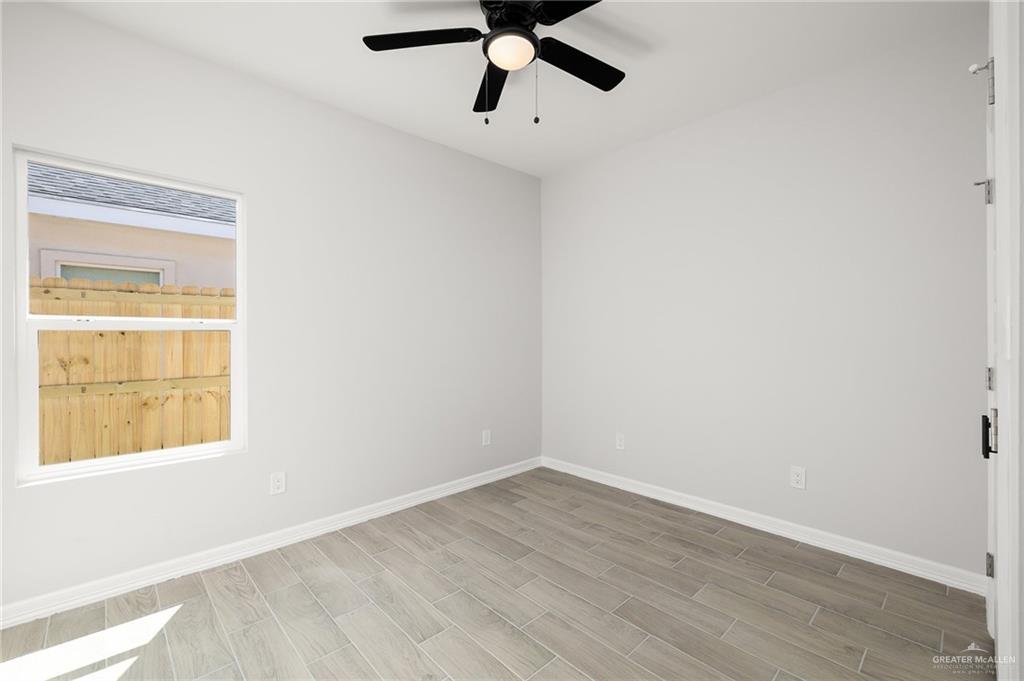 188 Farrell Road, Unit 1 Weslaco, TX 78596 - Photo 10 of 12 an empty room with a window and a ceiling fan