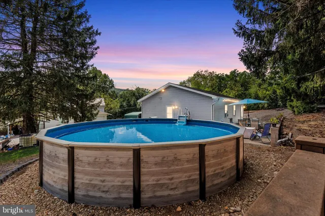 a view of a house with a swimming pool and a yard