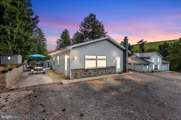 a view of a house with backyard space and a car parked in it