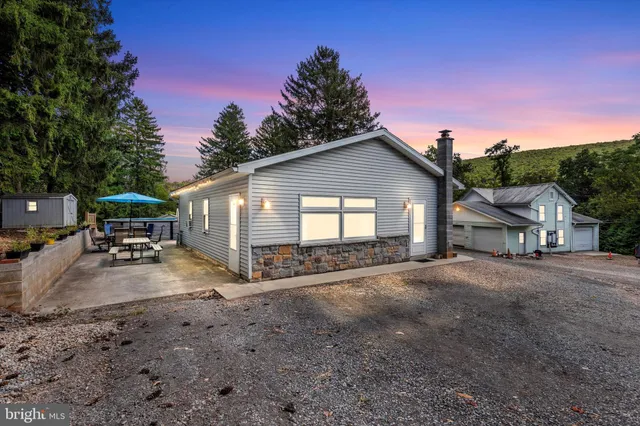 a view of a house with backyard space and a car parked in it