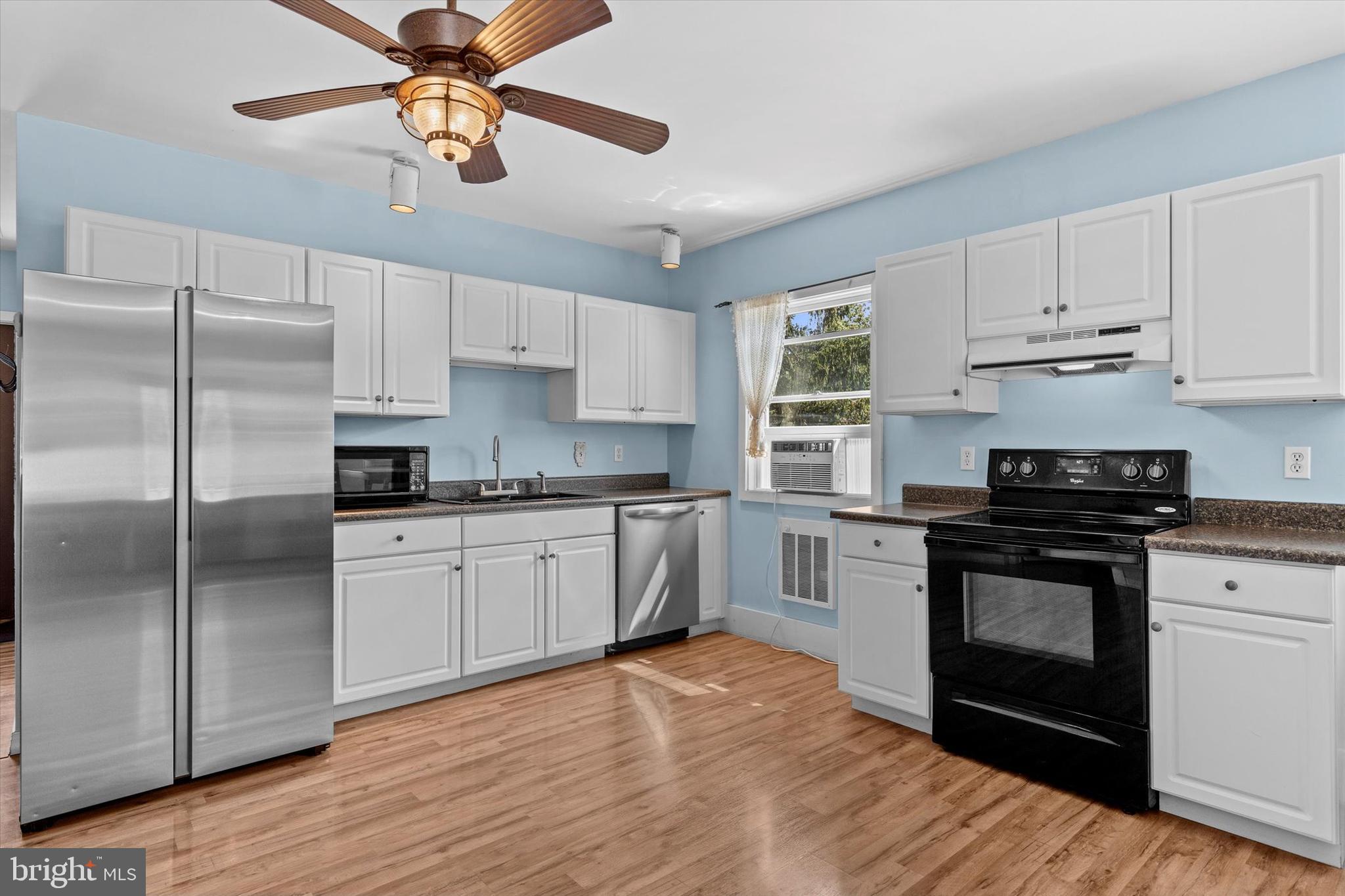239 Hill Street Lykens, PA 17048 - Photo 10 of 43 a kitchen with stainless steel appliances granite countertop a stove a refrigerator a sink and white cabinets