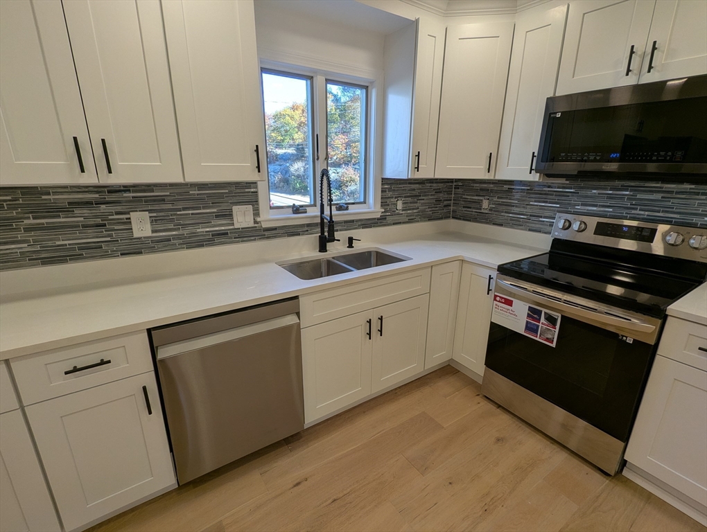 296 Fulton Street, Unit 1 Medford, MA 02155 - Photo 1 of 19 a kitchen with a sink and white cabinets