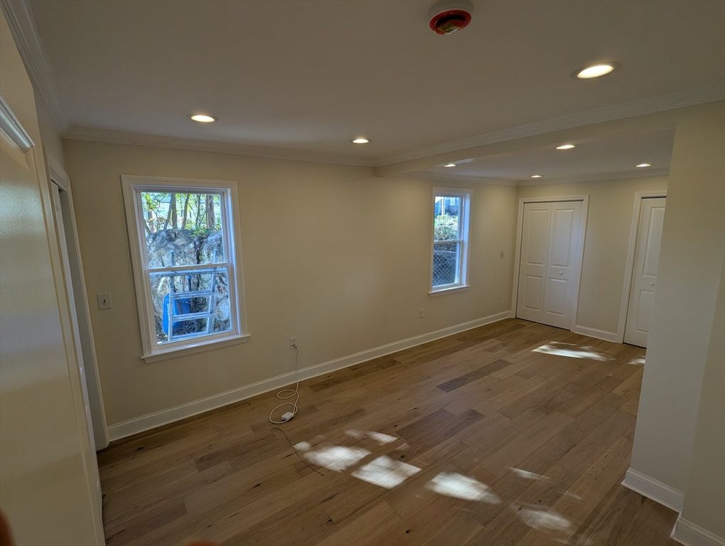 296 Fulton Street, Unit 1 Medford, MA 02155 - Photo 13 of 19 a view of an empty room with window and wooden floor
