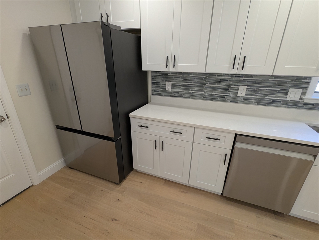 296 Fulton Street, Unit 1 Medford, MA 02155 - Photo 3 of 19 a view of a kitchen with refrigerator and cabinet
