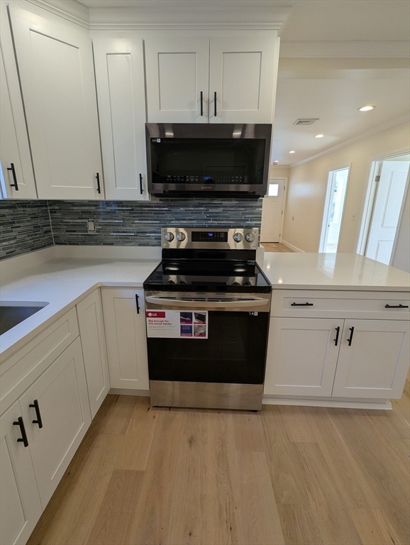 296 Fulton Street, Unit 1 Medford, MA 02155 - Photo 4 of 19 a kitchen with a stove and a microwave