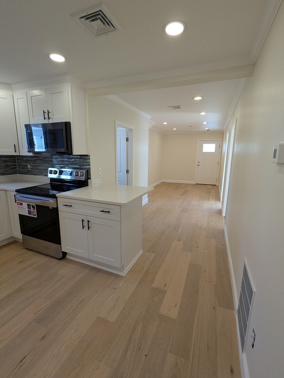 296 Fulton Street, Unit 1 Medford, MA 02155 - Photo 5 of 19 a kitchen with stainless steel appliances granite countertop a stove a sink and a refrigerator