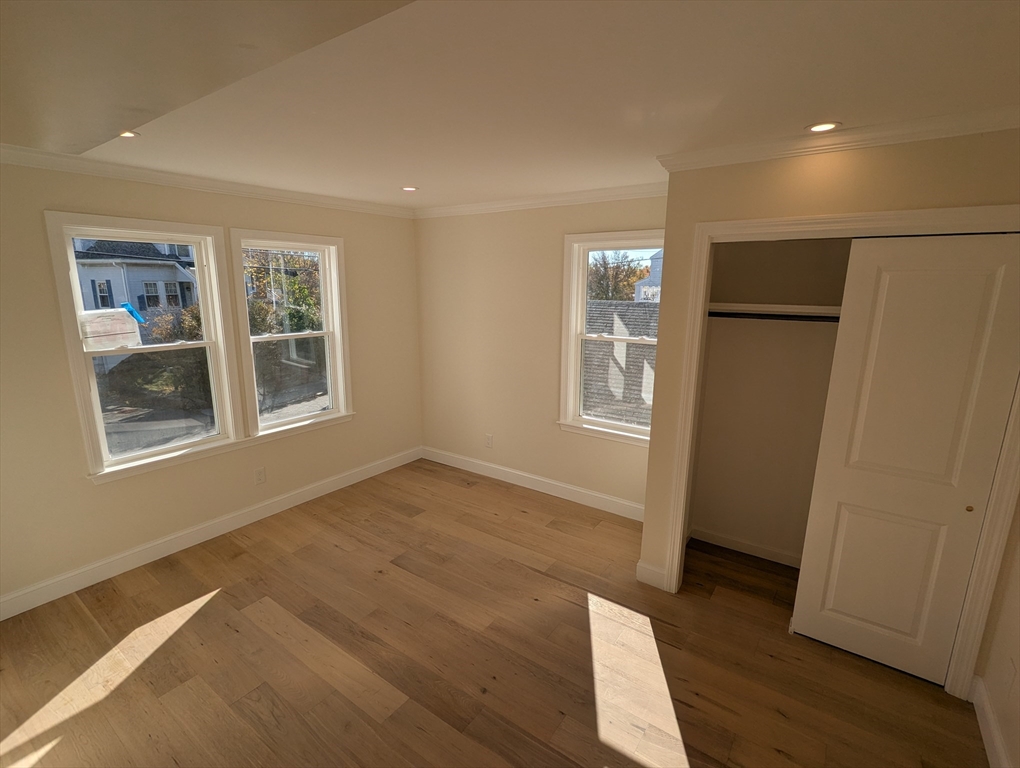 296 Fulton Street, Unit 1 Medford, MA 02155 - Photo 9 of 19 an empty room with wooden floor and windows