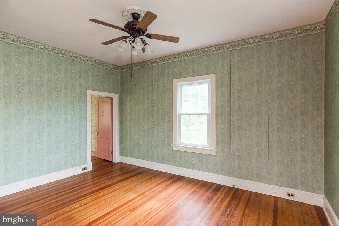 5760 Middleburg Road Keymar, MD 21757 - Photo 7 of 25 an empty room with wooden floor and windows