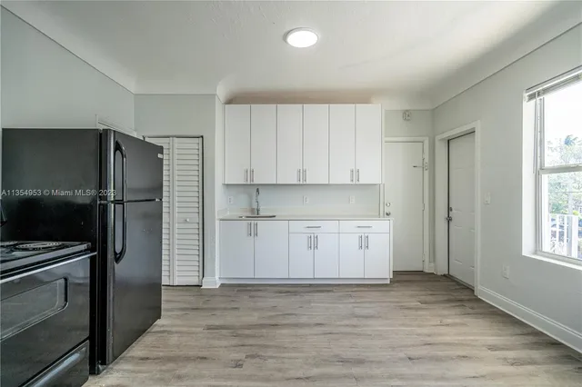 a kitchen with a refrigerator stove and wooden cabinets
