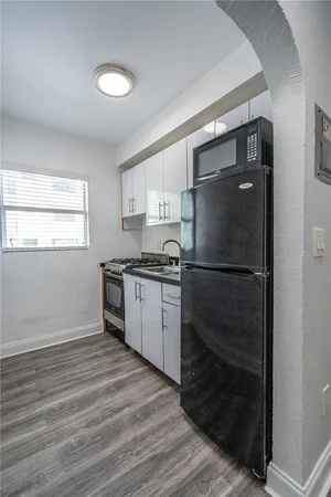 a kitchen with a refrigerator and a stove top oven