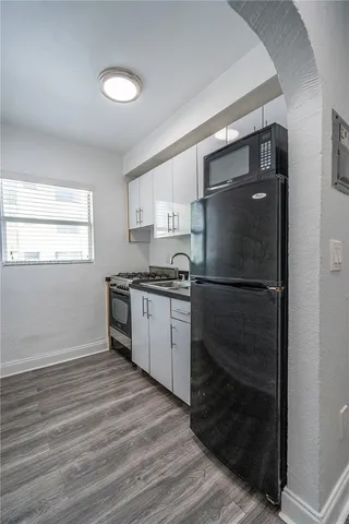 a kitchen with a refrigerator and a stove top oven