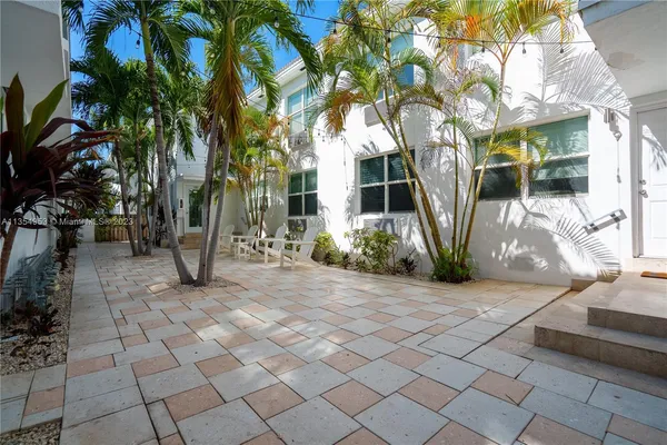 a front view of a house with a tree