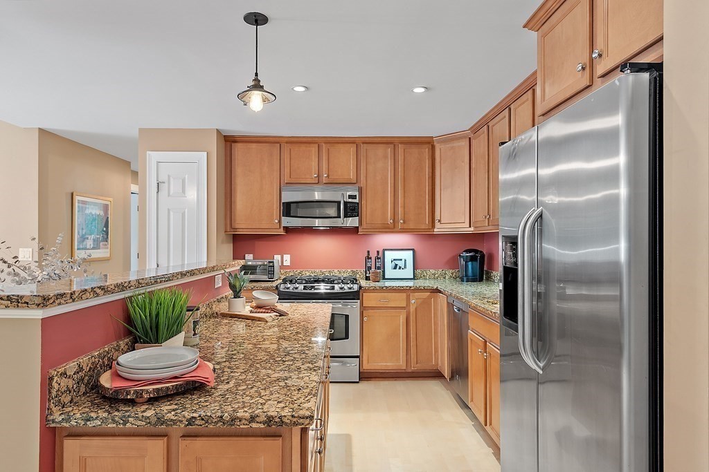 95 Conant Street, Unit 304 Concord, MA 01742 - Photo 4 of 23 a kitchen with stainless steel appliances granite countertop a sink refrigerator and microwave