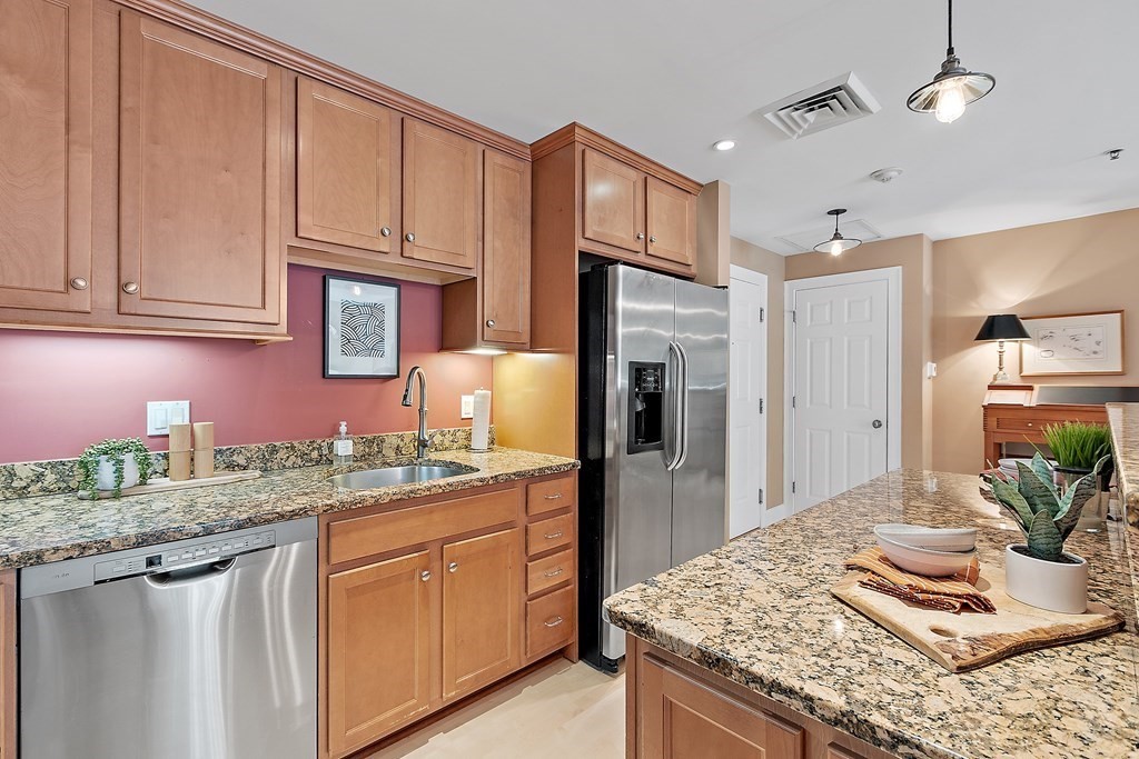 95 Conant Street, Unit 304 Concord, MA 01742 - Photo 5 of 23 a kitchen with granite countertop kitchen island stainless steel appliances a sink stove and refrigerator