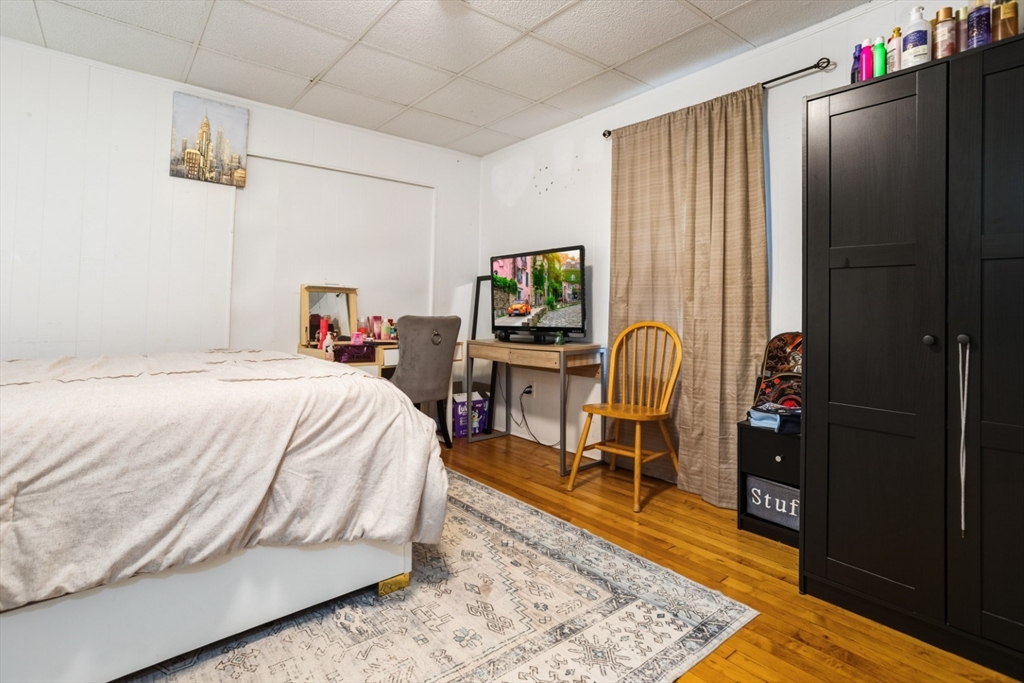 17 Ashton Street Everett, MA 02149 - Photo 20 of 42 a bedroom with a bed a table and chair