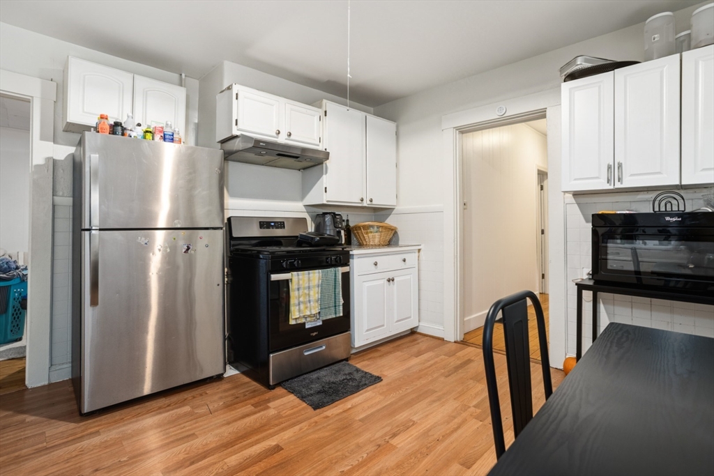 17 Ashton Street Everett, MA 02149 - Photo 10 of 42 a kitchen with stainless steel appliances granite countertop a refrigerator a stove and a wooden floors