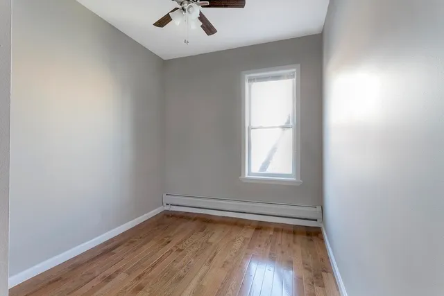 an empty room with a window and wooden floor