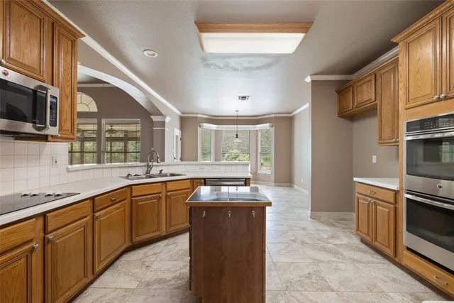 a kitchen with stainless steel appliances granite countertop a sink and wooden cabinets