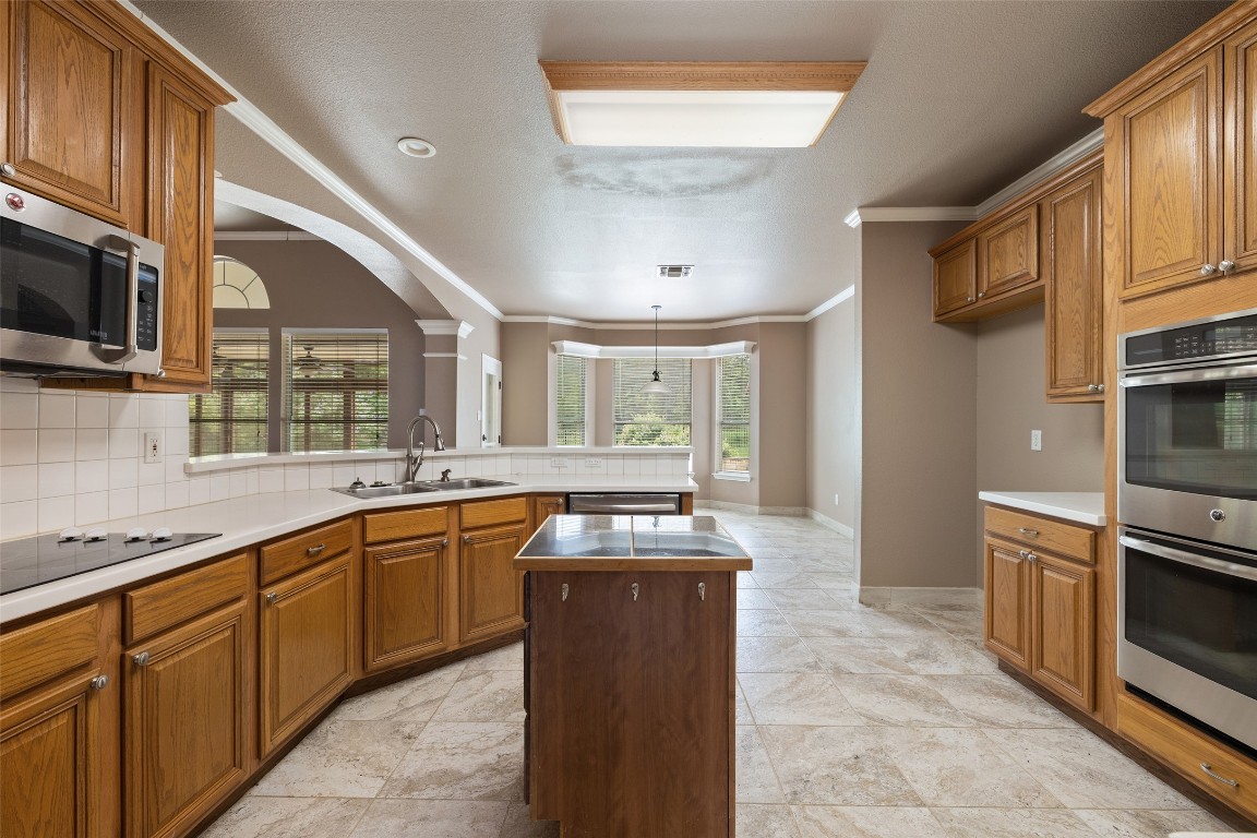 270 Rollin N Ranch Road Blanco, TX 78606 - Photo 17 of 27 a kitchen with stainless steel appliances granite countertop a sink and wooden cabinets