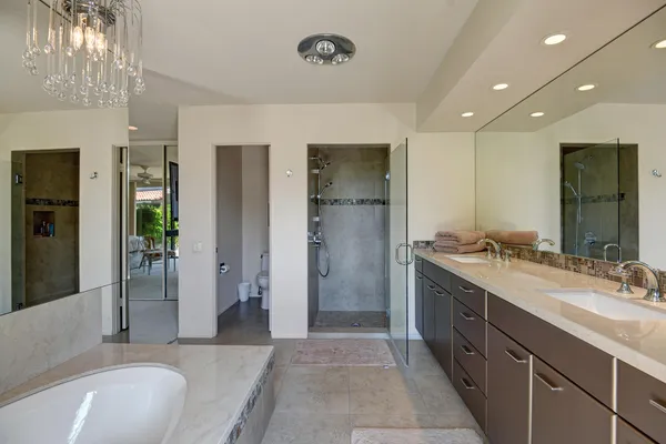 a spacious bathroom with a double vanity sink a large mirror and shower