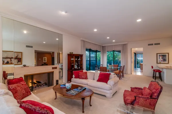 a living room with furniture fireplace and a large window