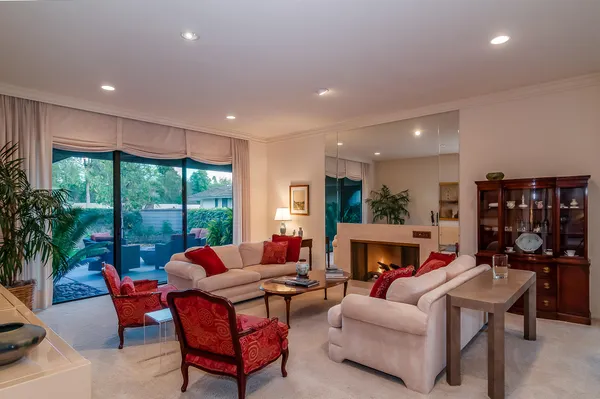 a living room with fireplace furniture and a large window