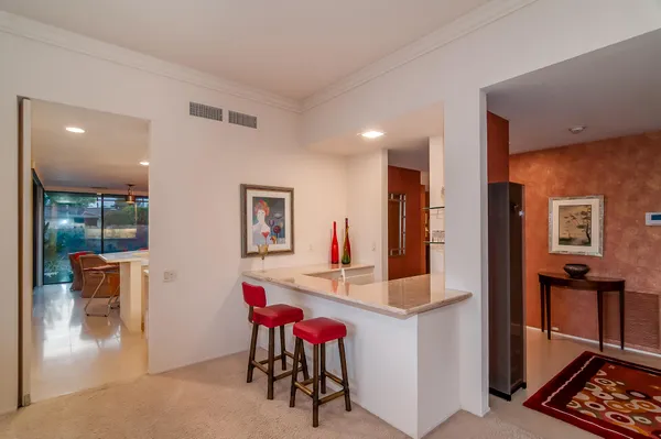 a very nice looking dining room with kitchen island a chandelier and a view of living room