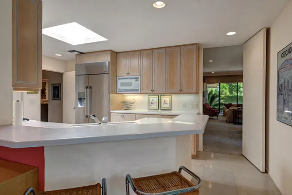 a kitchen with stainless steel appliances kitchen island granite countertop a refrigerator and a sink