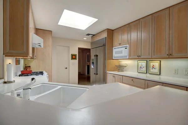 a kitchen with stainless steel appliances granite countertop a sink refrigerator and cabinets
