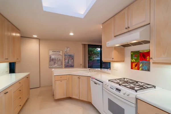a kitchen with granite countertop white cabinets and white appliances