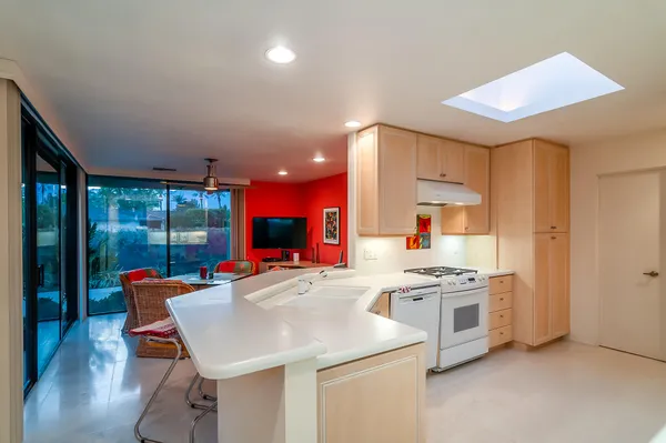 a kitchen with stainless steel appliances kitchen island granite countertop a stove a sink and a refrigerator