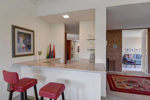 a living room with furniture and a painting on the wall