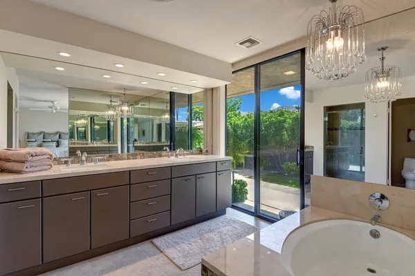 a bathroom with a tub sink shower and mirror