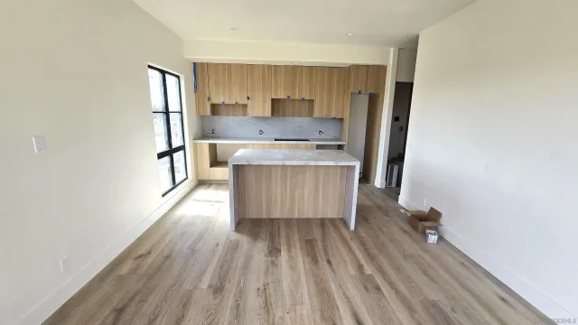 a kitchen with wooden floors and white cabinets