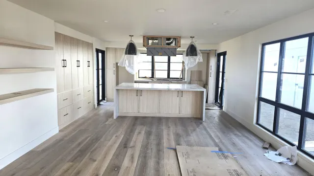 a view of a kitchen with wooden floor and electronic appliances