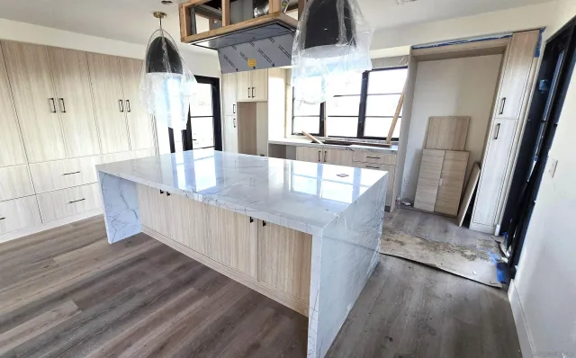 a kitchen with stainless steel appliances granite countertop a sink a stove and a wooden floors