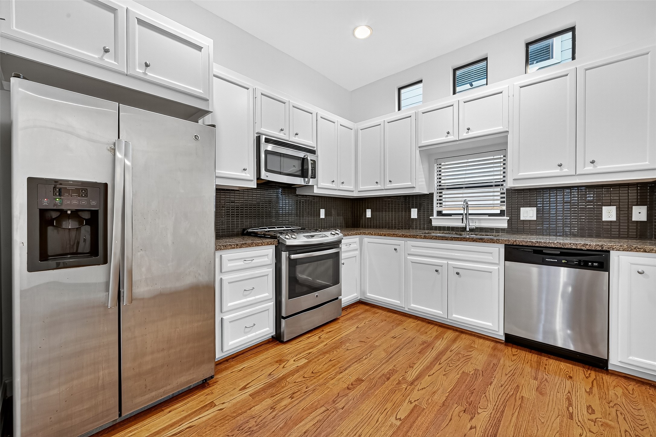 2710 Hullsmith Drive, Unit 1303 Houston, TX 77063 - Photo 7 of 25 a kitchen with granite countertop white cabinets and stainless steel appliances