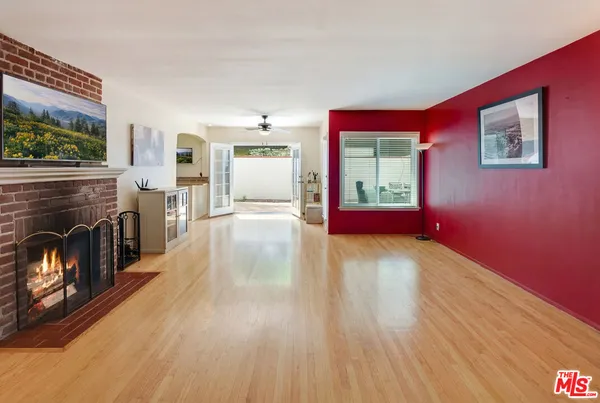 a view of a livingroom with wooden floor a fireplace and window