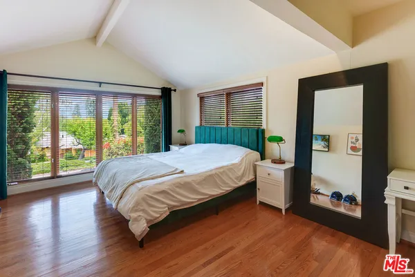 a bedroom with a bed and a large window