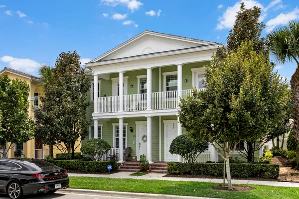 a front view of a house with a garden and trees