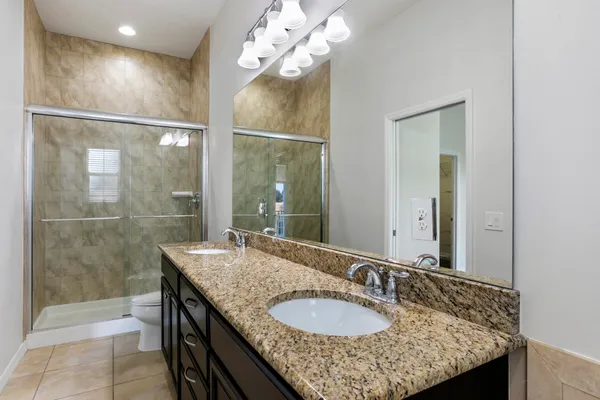 a bathroom with a granite countertop sink a toilet and a mirror
