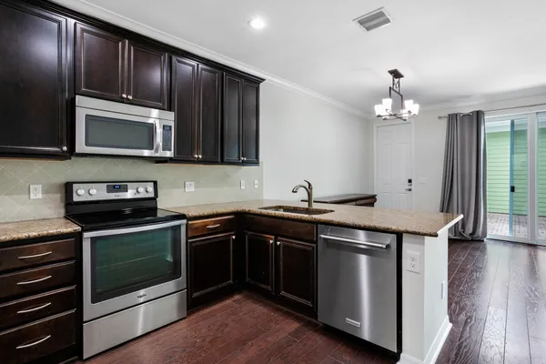 a kitchen with stainless steel appliances granite countertop a refrigerator and a stove top oven