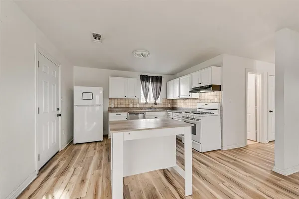 a kitchen with white cabinets and stainless steel appliances