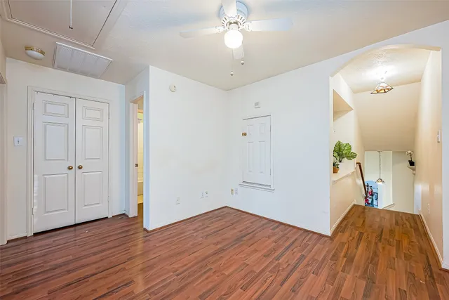 a view of a room with wooden floor and a ceiling fan