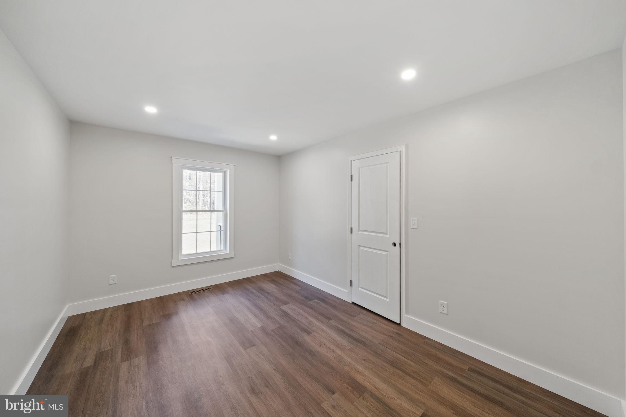 646 Sandy Point Road Heathsville, VA 22473 - Photo 12 of 39 a view of an empty room with wooden floor and a window