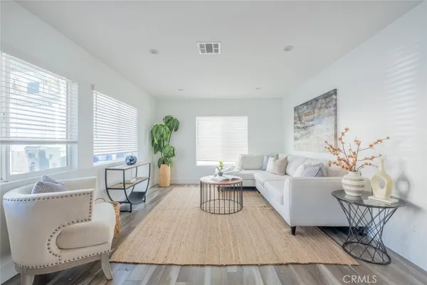 a living room with furniture wooden floor and a table