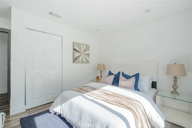 a bedroom with a bed and a painting on the wall