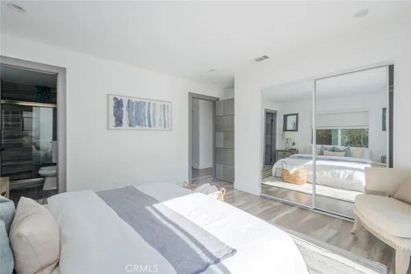 a bedroom with a bed and a large mirror