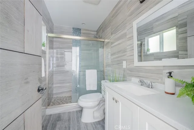 a bathroom with a sink a toilet and shower